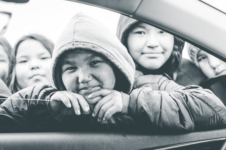 Young Kids Looking Through Cars Window