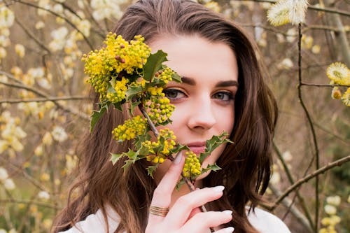 Free Woman Taking Photo With Holding Yellow Flower Buds at Daytime Stock Photo