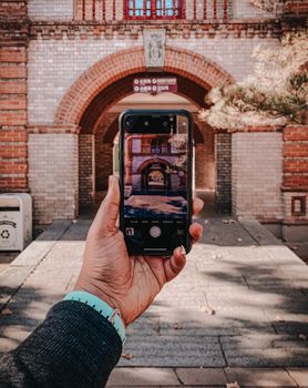 Close-up of hand holding a smartphone capturing an archway in Beijing, China.