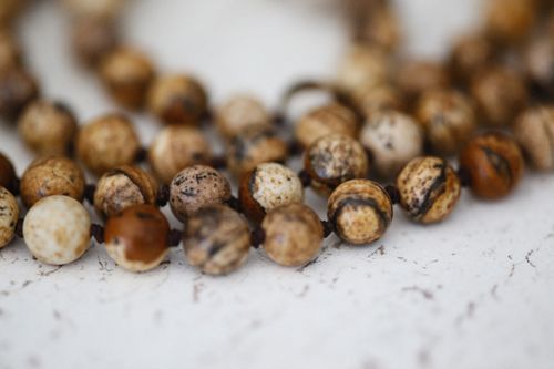 Free Detailed close-up of a natural stone beaded necklace with earthy tones. Stock Photo