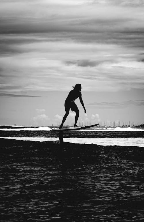 Grayscale Photo of a Person Foil Surfing