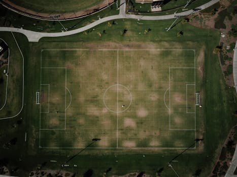 Drone shot of a soccer field in California park, showcasing green layout and surrounding paths.