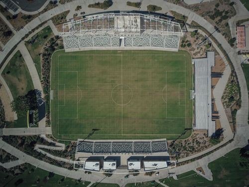 Free High-angle aerial shot capturing the details of a soccer stadium and surrounding sports complex. Stock Photo