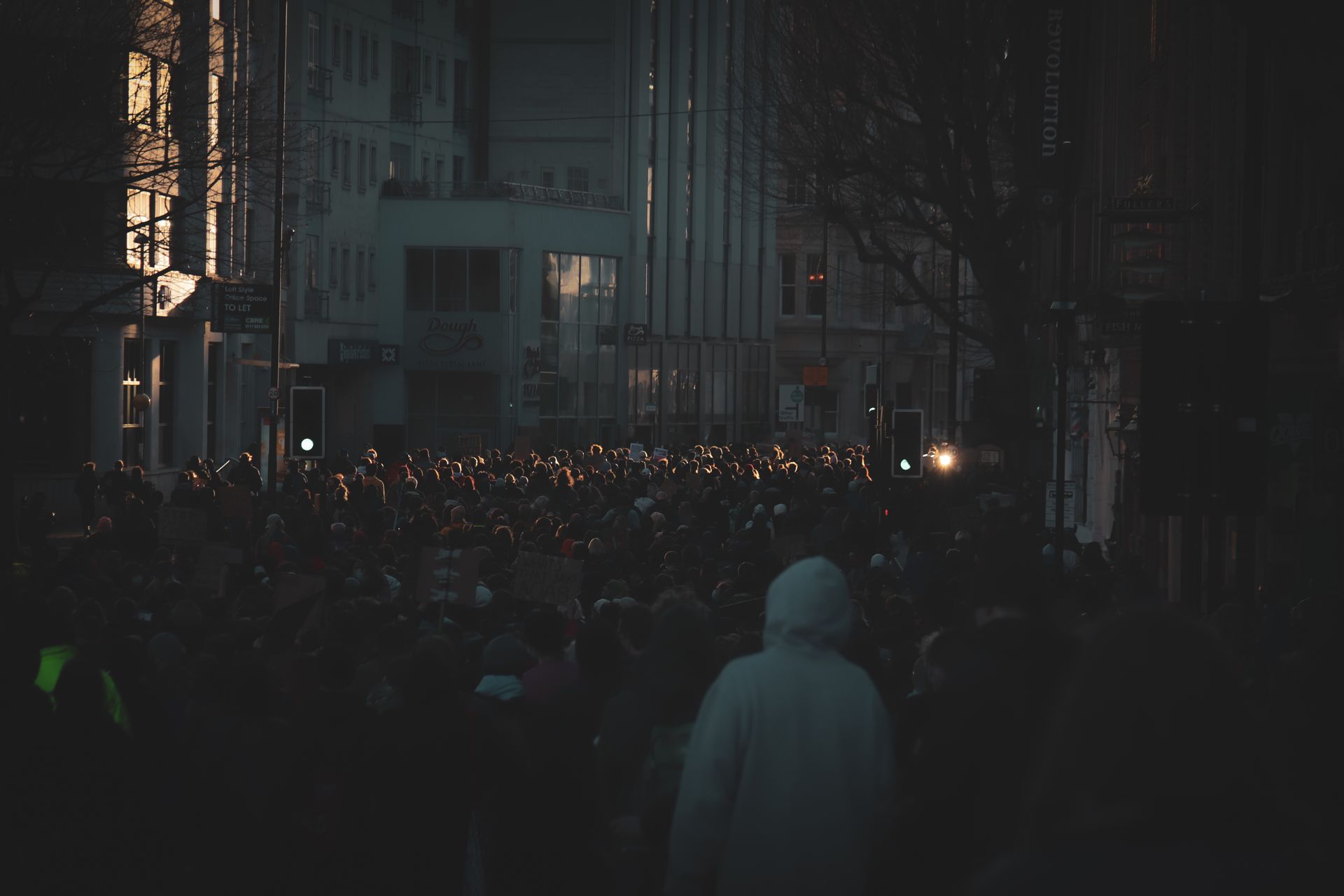 Une foule de manifestants rassemblée dans une rue le soir