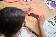 View on kid preparing pumpkin decoration for Halloween