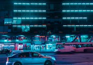 霓虹灯照亮了繁华的都市夜景，汽车和公共巴士在街道上穿行