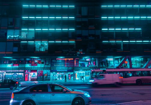 霓虹灯照亮了繁华的都市夜景，汽车和公共巴士在街道上穿行