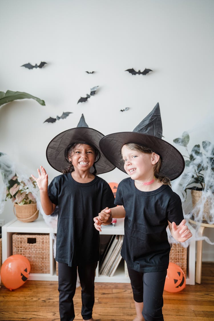 Two Young Girls Smiling In Witch Hats