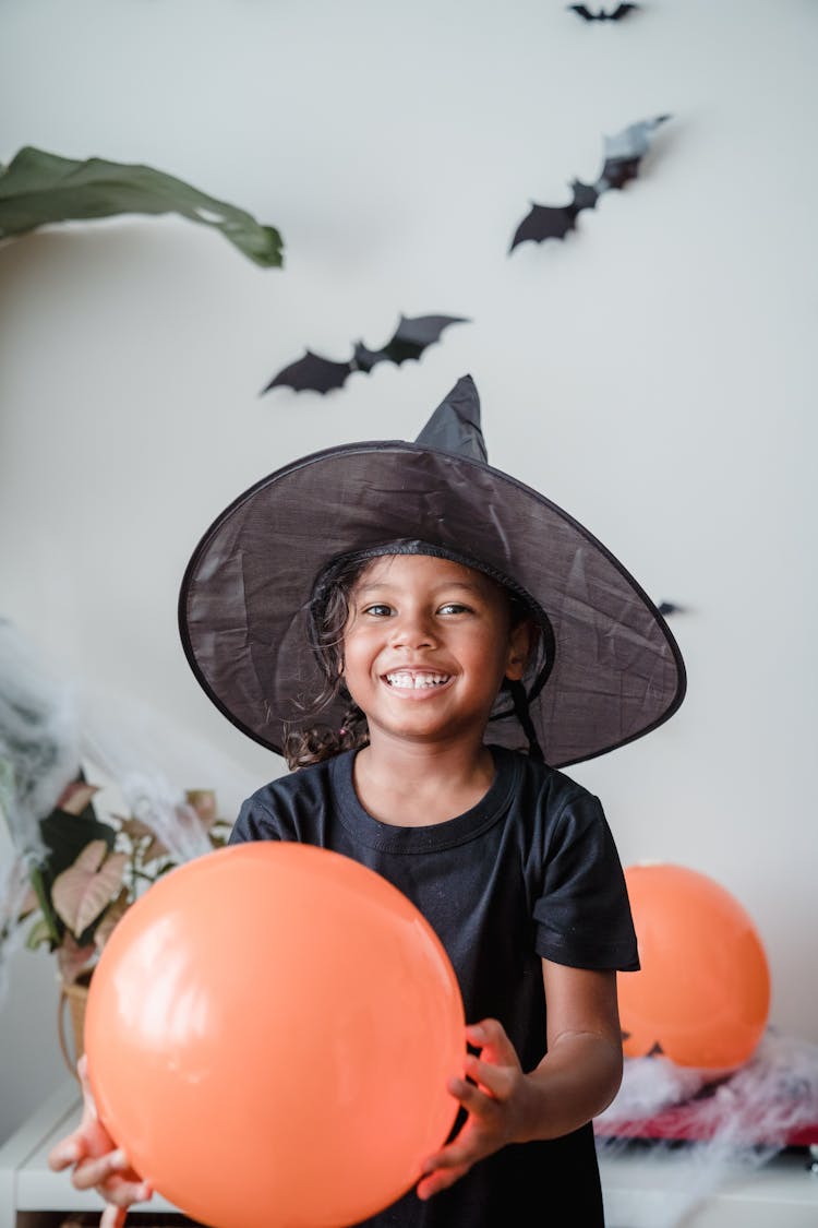 Young Girl In Witch Costume And Smiling