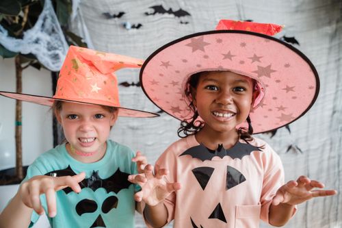 Free Children dressed in Halloween costumes having fun indoors, embodying spooky joy. Stock Photo