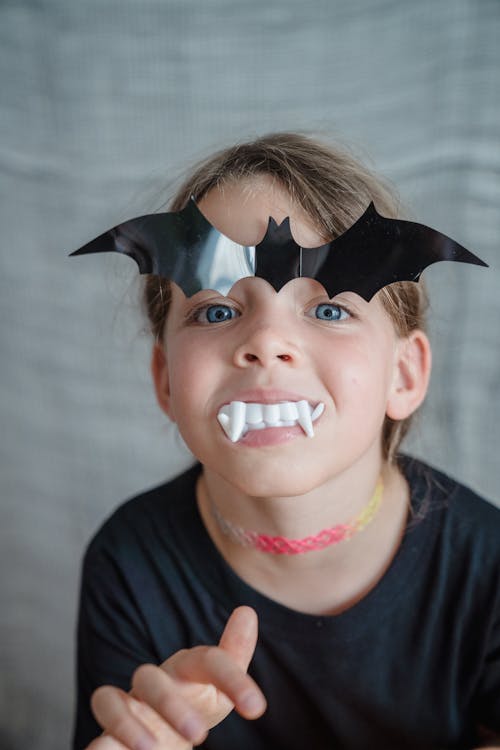 Young girl with toy bath and teeth on her face