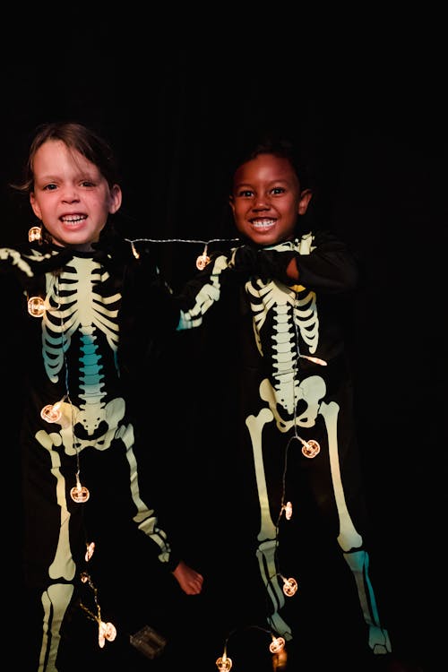 Studio shot of two kids dressed as skeletons