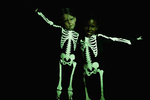 Standing girls in skeleton costumes