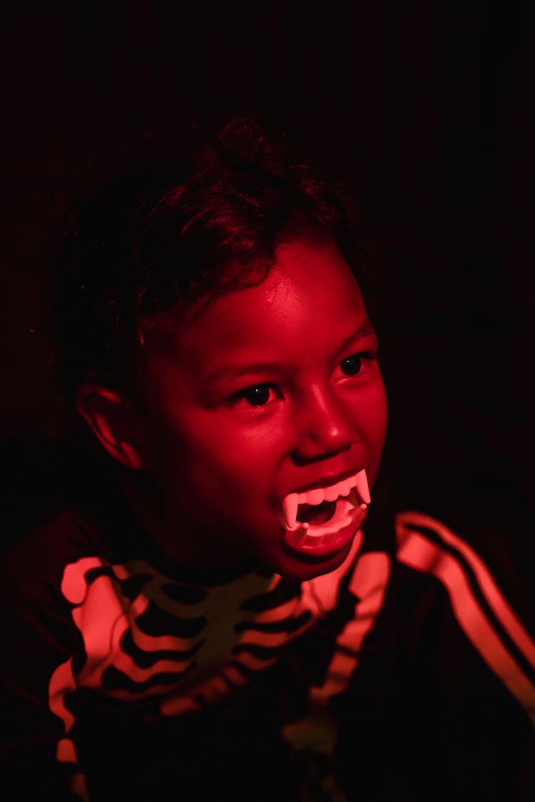 Kid Dressed As Skeleton And With Toy Teeth In Mouth