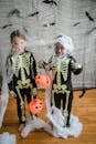 Two kids in skeleton costumes tangled in net