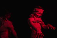 Girls wearing mummy costumes in red-lighted room