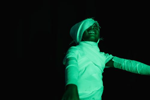 Free Child in a mummy costume having fun with dramatic lighting on a dark background. Stock Photo