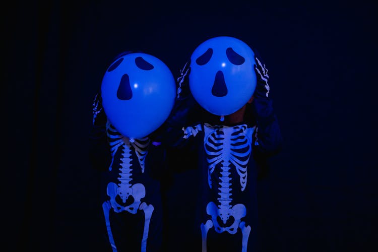 2 Children Holding Ballons With Scary Faces