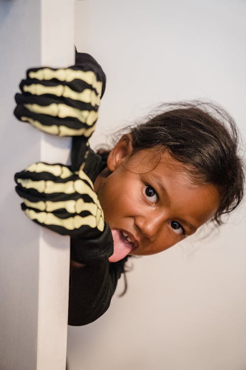 Girl wearing skeleton costume and putting out tongue