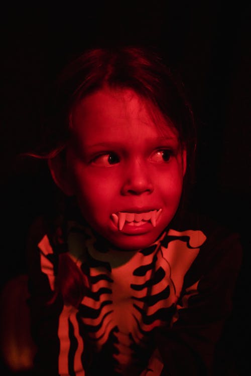Child with fake teeth in a red light