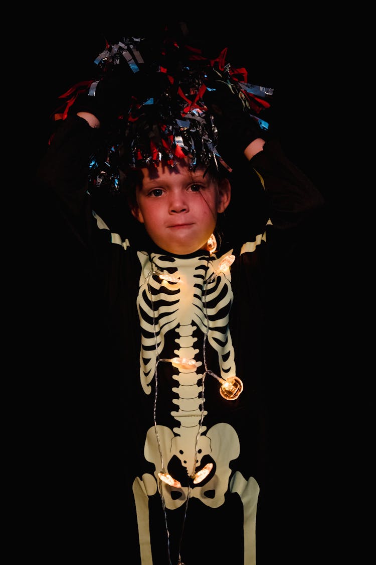 Kid Wearing Skeleton Costume And Hat Made Of Foil Strips