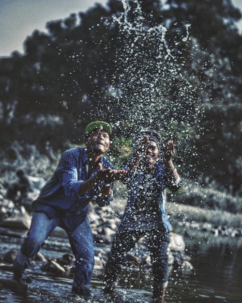 Двое мужчин играют с водой в озере