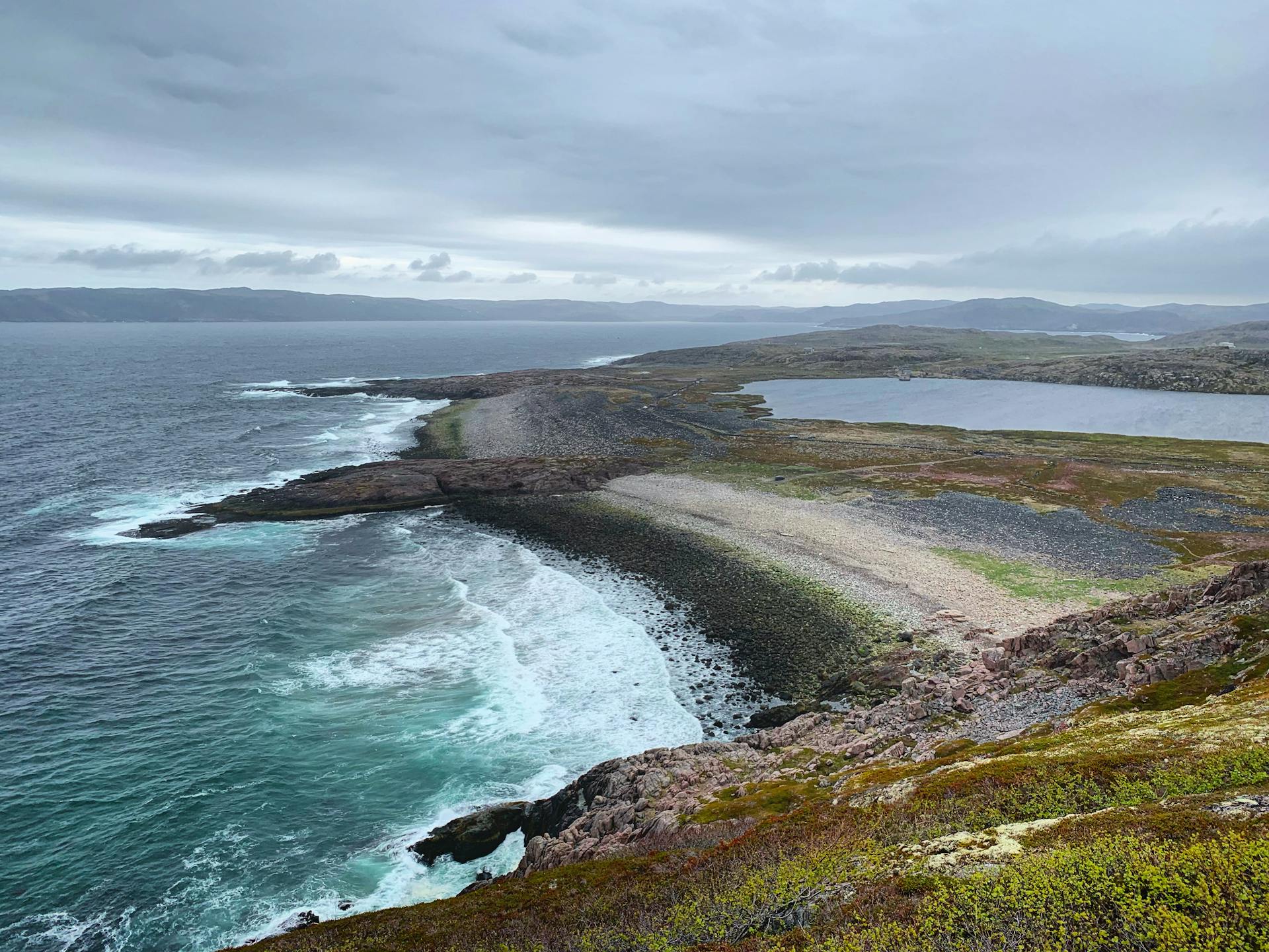 A breathtaking view of the rugged Murmansk coast with crashing waves and expansive seascape.