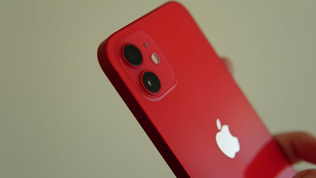Close-up of a red smartphone with a dual camera and iconic logo.