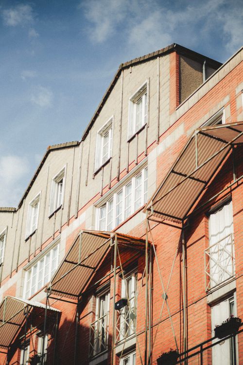 Free Low angle view of a red brick building exterior under a blue sky. Architectural design and details stand out. Stock Photo