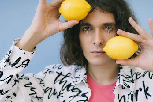 Man in make-up holding lemons