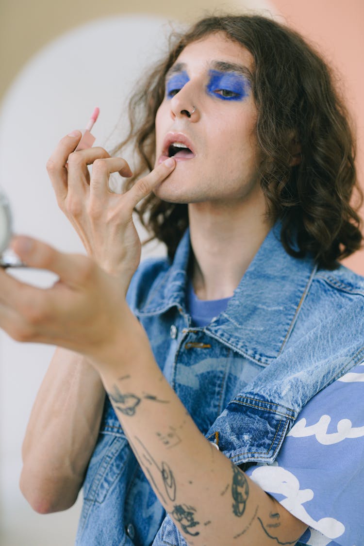 Portrait Of Man With Make-up Applying Lipstick