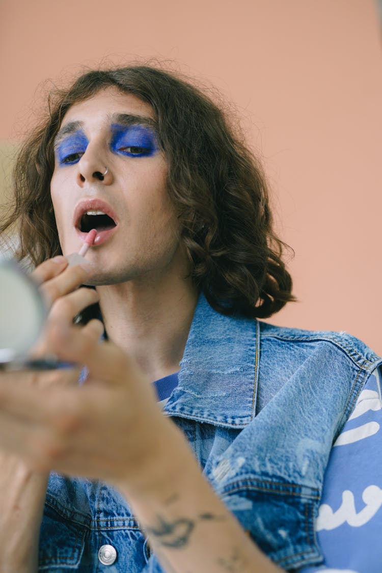 Man In Denim Jacket Applying Lipstick