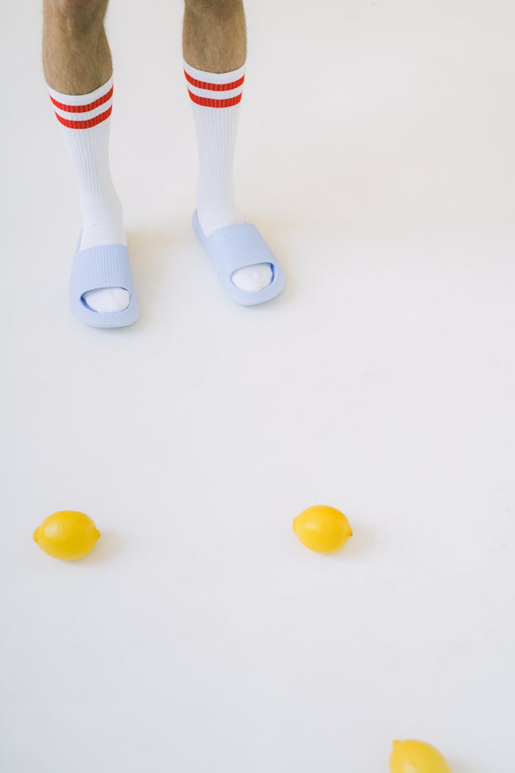 High Angle View Of Man In Flip Flops And Lemons