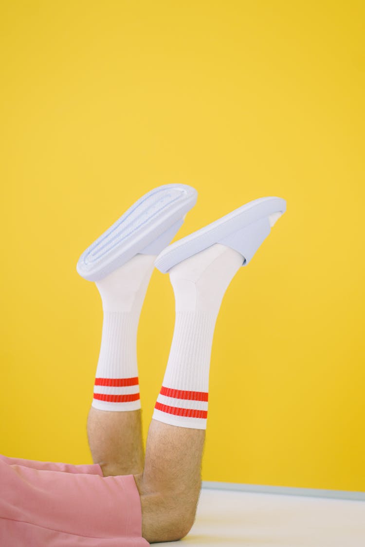 Mans Legs In White Socks On Yellow Background