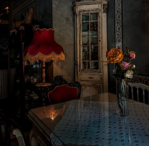 Free Elegant vintage dining room with warm lighting and floral centerpiece on table. Stock Photo