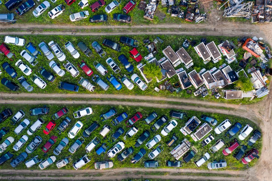 Top view of a junkyard with rows of parked cars, showcasing recycling concept.