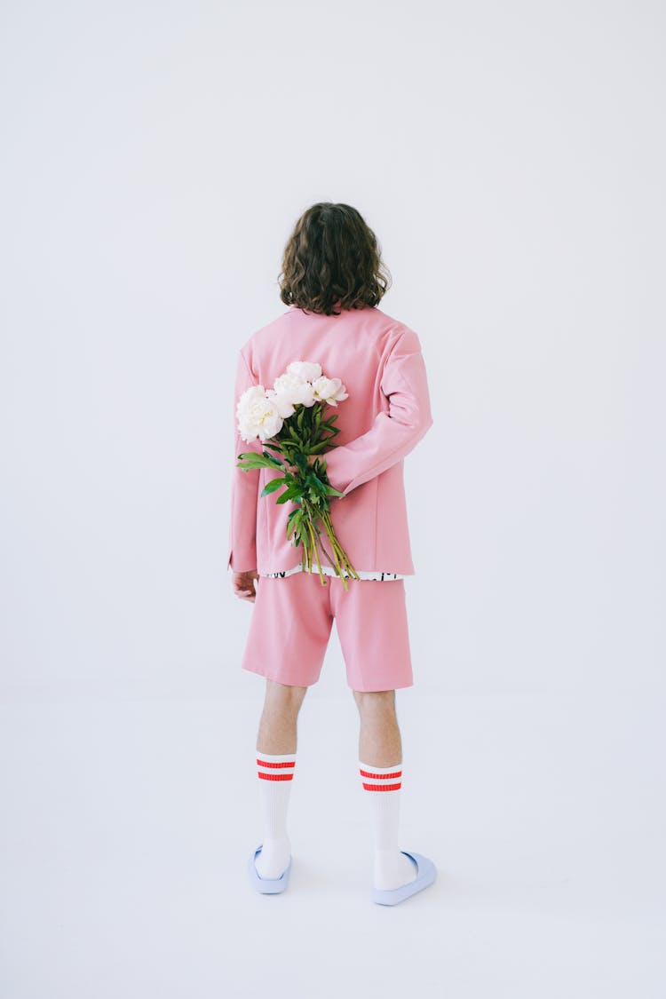 Man In Pink Clothes Holding Flowers At His Back