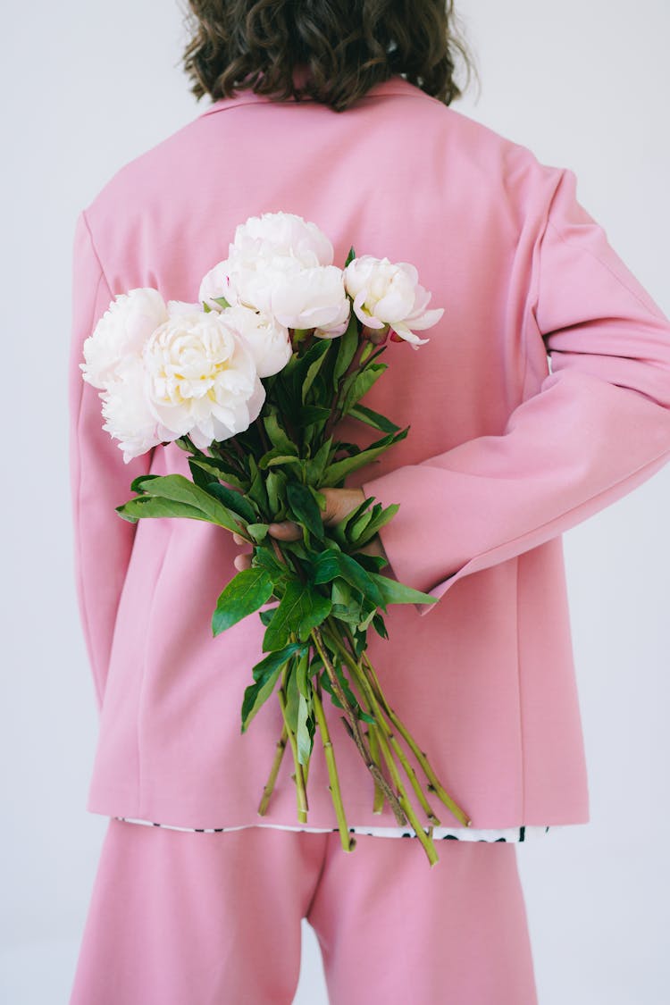 A Man Holding A Bunch Of Flowers Behind His Back 