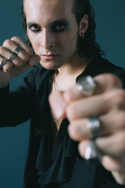 Free Close-up of a stylish adult with bold makeup and rings posing indoors. Stock Photo
