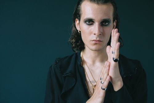 Free Stylish portrait of a model with bold makeup, long hair, and rings in a studio setting. Stock Photo