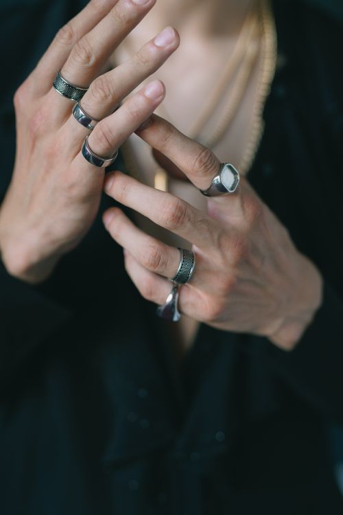 Free A stylish close-up of male hands wearing rings and chains, showcasing elegance and fashion. Stock Photo