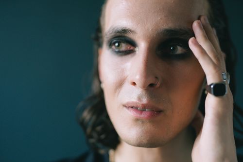 Free Intimate close-up shot focusing on eye makeup and facial expression with a hand gently touching the face. Stock Photo
