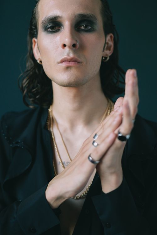 Free Stylish portrait of a man with gothic makeup and jewelry, exuding confidence. Stock Photo
