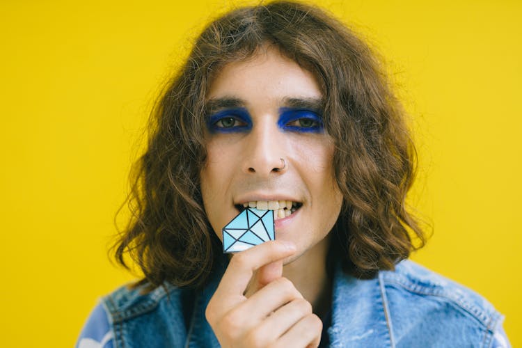 Man With Blue Eyeshadow Biting A Diamond