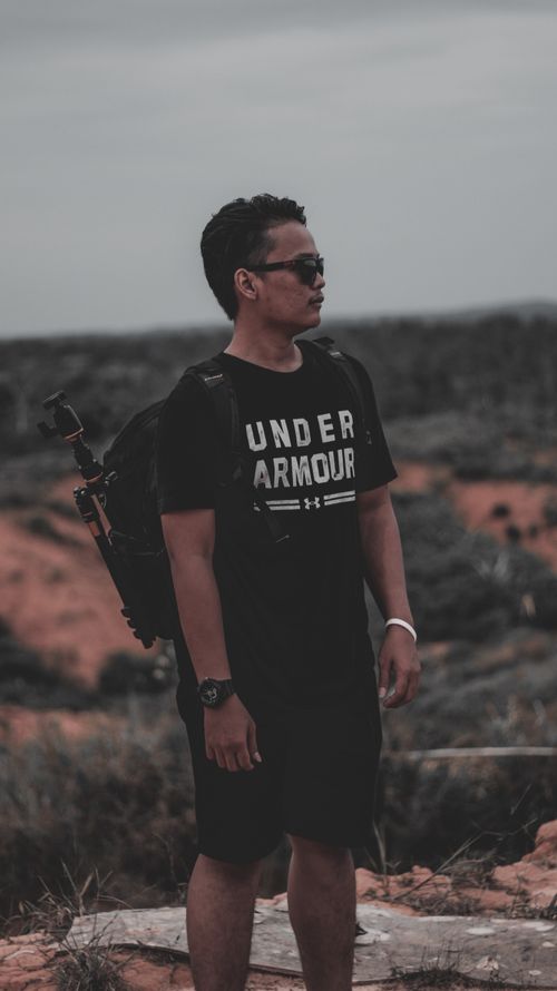 Free Man on a scenic outdoor adventure, wearing casual attire and sunglasses. Stock Photo