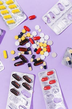 Close-up of various pills and capsules on a purple backdrop, showcasing pharmaceutical diversity.