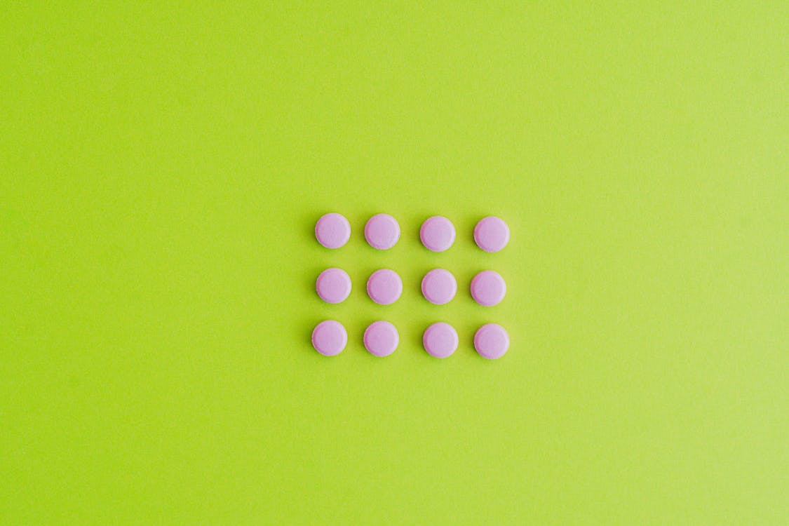 Pink Pills on Green Surface