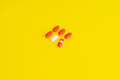 Orange Medication Pill on Yellow Surface