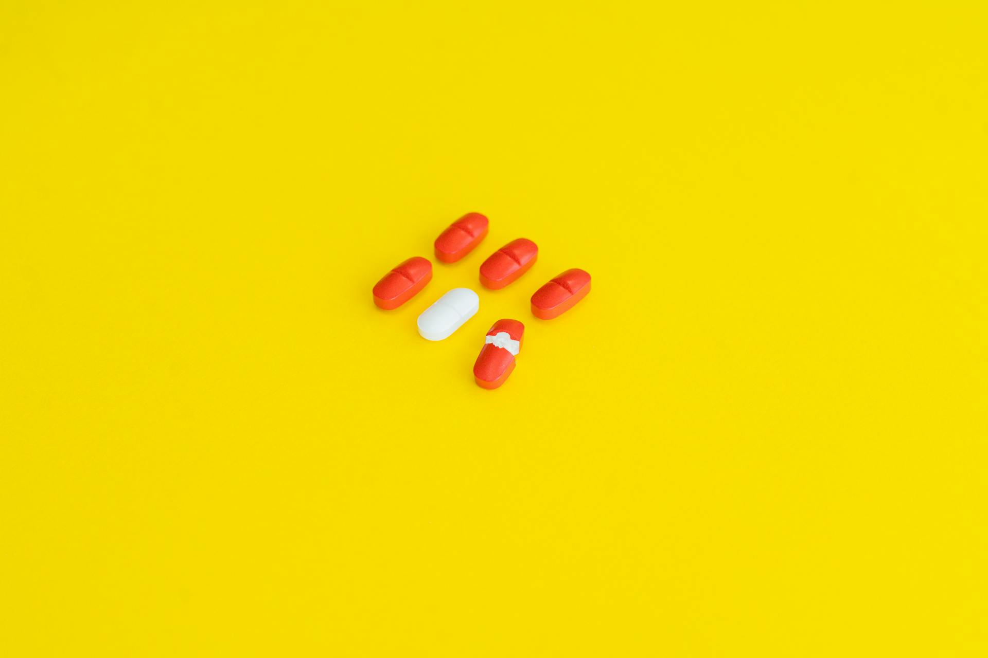 Orange Medication Pill on Yellow Surface