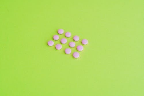 Pink Round Medication Pill on Green Surface